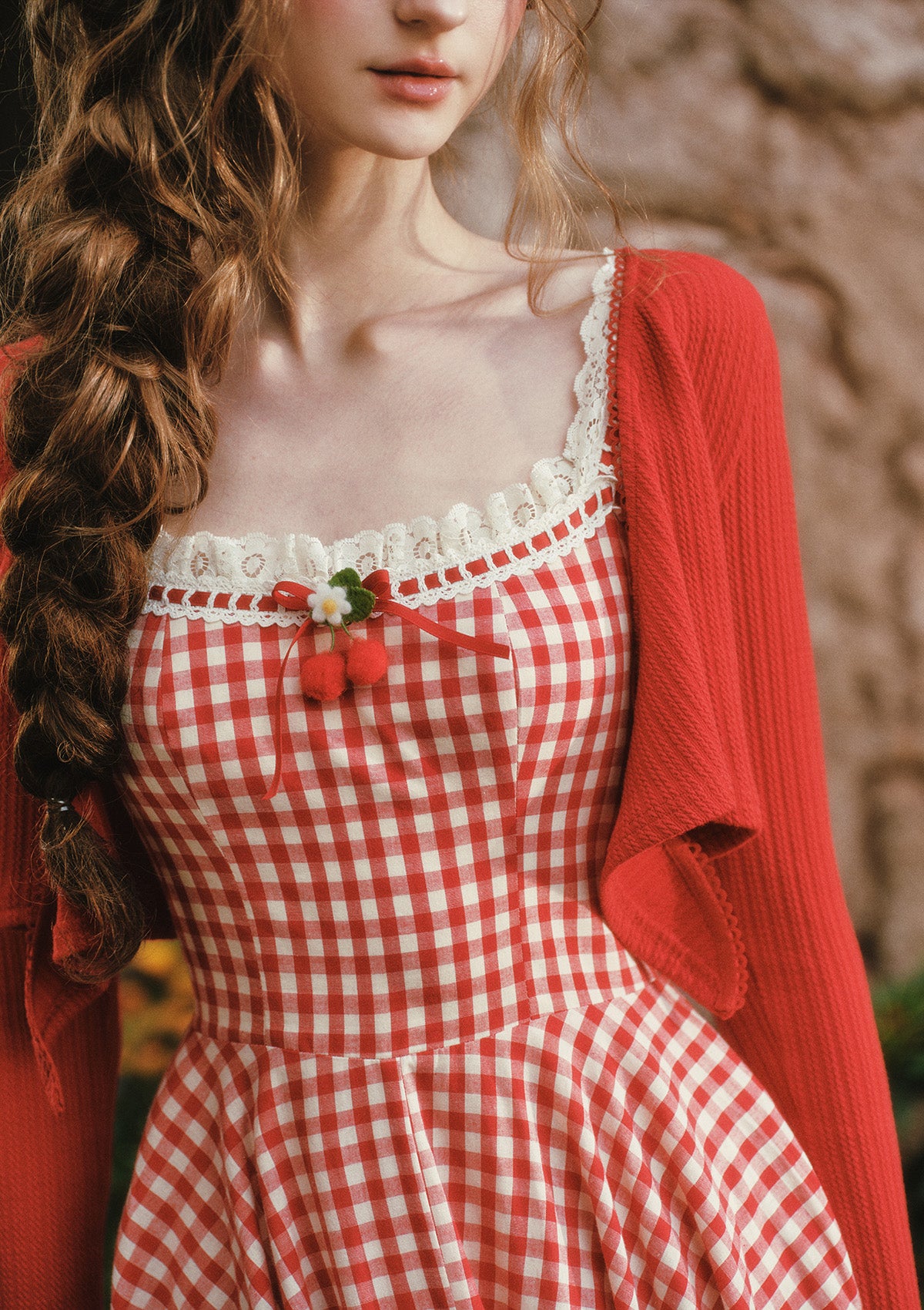 Close-up of lace trim and berry charm on Lacemade gingham dress