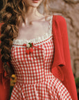 Close-up of lace trim and berry charm on Lacemade gingham dress